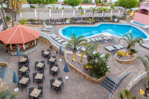 美洲海滩马洛拉公园酒店的享有带桌椅的度假村游泳池的顶部景致