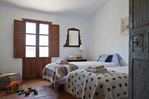 Olías胡安萨尔瓦多科尔蒂霍酒店的一间卧室配有两张床和镜子