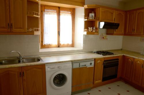 锡古恩萨Casa Rural ALCARREÑA的厨房配有水槽和洗衣机