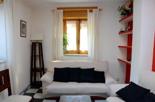 锡古恩萨Casa Rural ALCARREÑA的客厅配有白色沙发和窗户