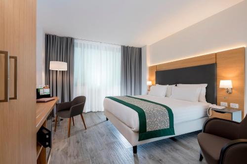 那不勒斯那不勒斯假日酒店的酒店客房设有一张大床和一张书桌。