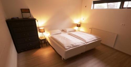 阿克雷里Manahlid Apartment的一间卧室配有一张床、一个梳妆台和一扇窗户。