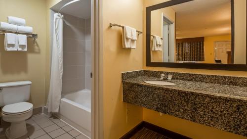 圆石城Days Inn by Wyndham Round Rock的一间带水槽、卫生间和镜子的浴室