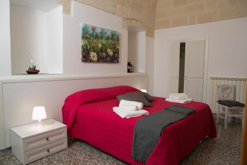 拉泰尔扎Il Rifugio di Laerte的卧室配有红色的床和墙上的绘画