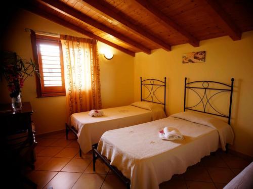 Aci SantʼAntonio卡萨洛托住宿加早餐旅馆的黄色墙壁客房的两张床