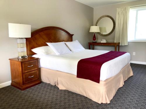 乔治湖山中旅馆的一间卧室配有一张大床和一张带镜子的桌子
