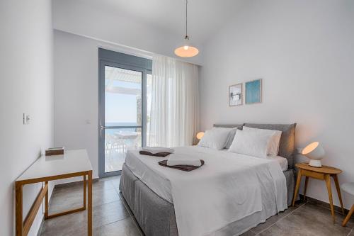 vlichaVilla Armonia的白色的卧室设有一张大床和一个窗户