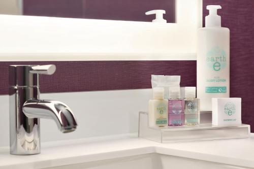 埃德蒙顿埃德蒙顿普拉扎APA海岸酒店的浴室水槽,内有肥皂和其他产品