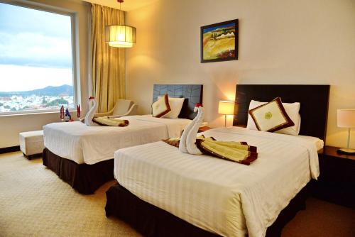 邦美蜀西贡帮美酒店的酒店客房设有三张床和大窗户