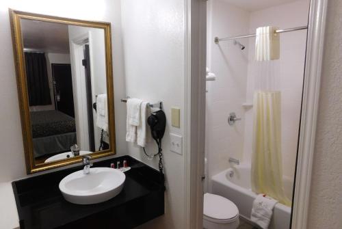 Warr AcresDays Inn by Wyndham Oklahoma City NW Expressway的一间带水槽、卫生间和镜子的浴室
