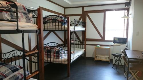 大村市BFH村庄旅馆的客房设有四张双层床和一张书桌。