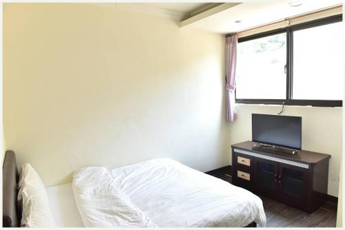 南竿莲园民宿一馆的一间卧室配有一张床和一台平面电视
