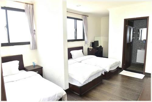 南竿莲园民宿一馆的一间卧室配有两张床和镜子