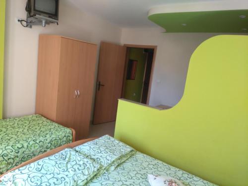 索科矿泉村Studio Milojević Sokobanja的一间卧室设有两张床和绿色床头板