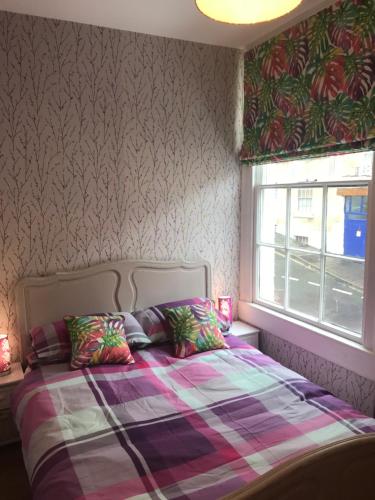 巴斯Central city pad one bedroom plus double sofabed的一间卧室配有一张带铺着地毯的床和窗户。