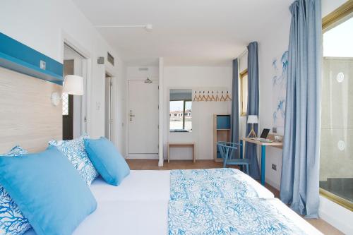 萨洛萨洛海滩皮埃尔假日酒店 的一间卧室配有一张带蓝色枕头的大床