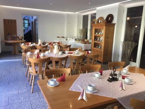 上阿斯巴赫Gästehaus - Kretschmannshof的用餐室配有桌椅和餐巾