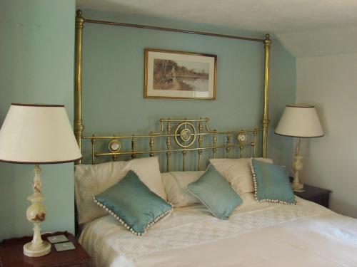 沃丁顿Chapel Cottage Clitheroe Road的一间卧室配有一张带枕头的床和两盏灯。