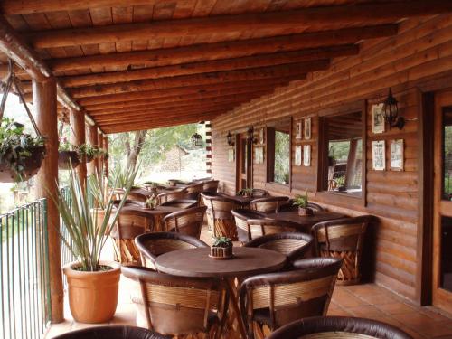 马萨米特拉Sierra Paraiso Hotel的门廊上设有桌椅的餐厅