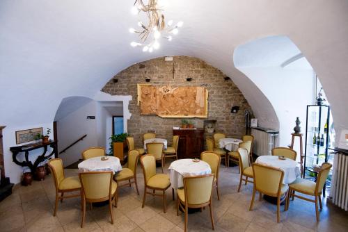 特雷斯科雷巴尔内亚廖阿尔伯格黛拉托瑞餐厅酒店的配有桌椅的房间和砖墙