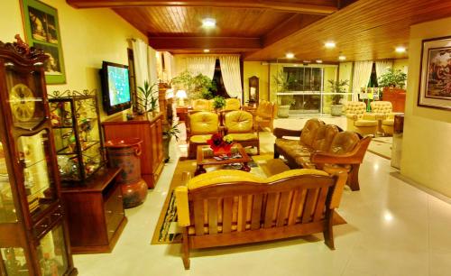 格拉玛多Hotel Sky Gramado的客厅配有家具和电视。