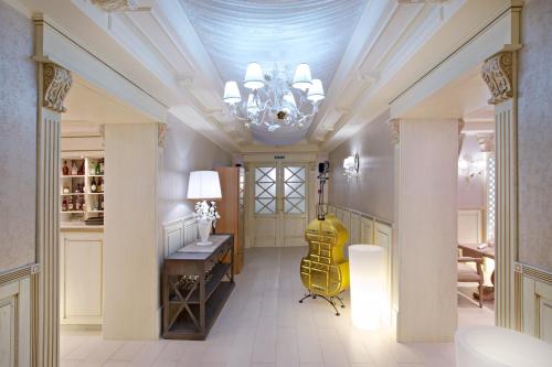 阿尔马维尔经典大酒店的走廊上设有吊灯、桌子和黄色吉他