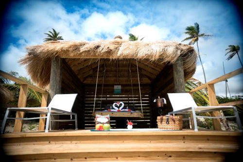 维约堡Serenity at Coconut Bay - All Inclusive的小屋设有两把椅子和茅草屋顶