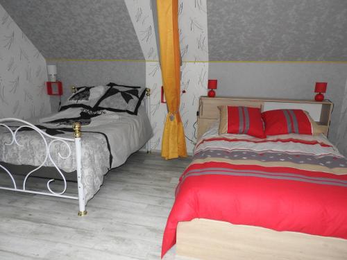 ChâteauvieuxLe paradis des caves的一间卧室配有两张带红色和黑色枕头的床