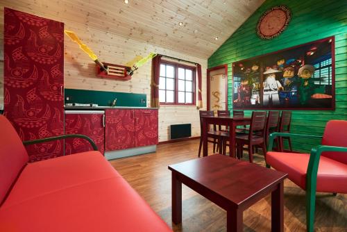 比伦德LEGOLAND NINJAGO Cabins的客厅配有红色的沙发和桌子