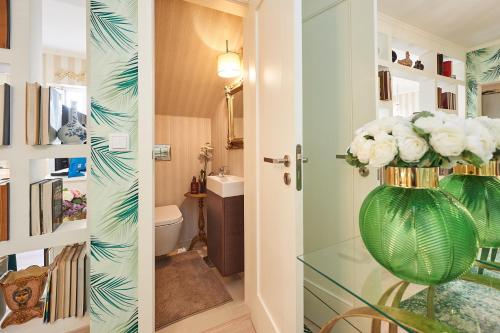 埃斯托利尔Luxurious triplex near the beach In Estoril的浴室内有白色花卉,绿花瓶