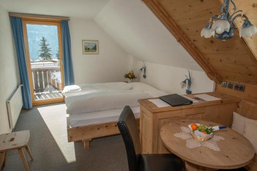 施库尔特劳贝酒店的一间卧室配有一张床、一张桌子和一张桌子