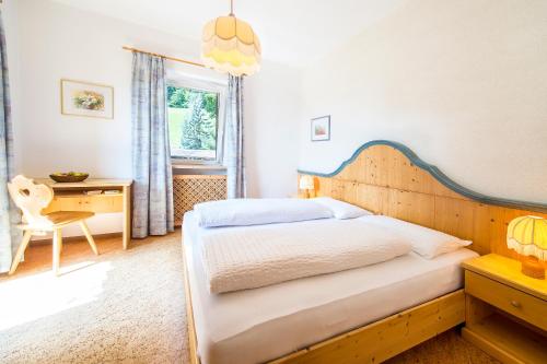 阿皮亚诺苏拉斯特拉达Gasthof Wieser的一间卧室配有一张床、一张书桌和一个窗户。