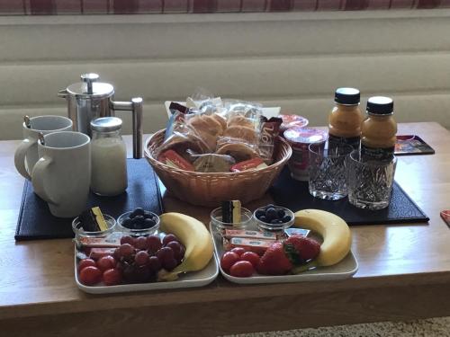 奥本Gramarvin B&B的一张桌子,上面放着两个盘子的食物和一篮水果