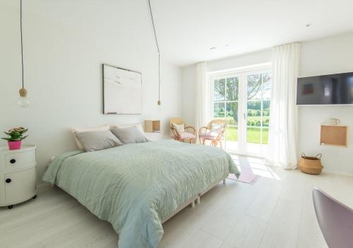 索尔图姆Kunstart20的白色卧室配有床和桌椅