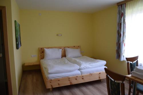 哈特贝格Der Schildbacherhof的一间卧室配有带白色床单和枕头的床。
