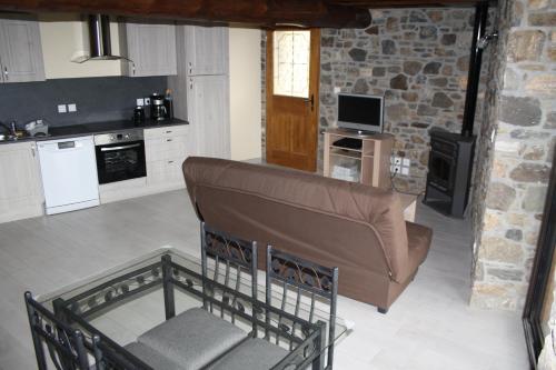 Axiatla forge d'andribet的客厅设有厨房,配有棕色沙发