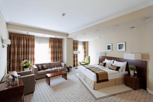 布加勒斯特首府广场酒店的酒店客房设有一张大床和一张沙发。