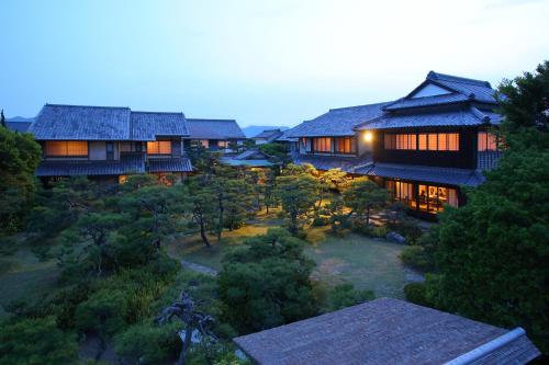 唐津洋阁日式旅馆的享有树木林立的房子的顶部景色