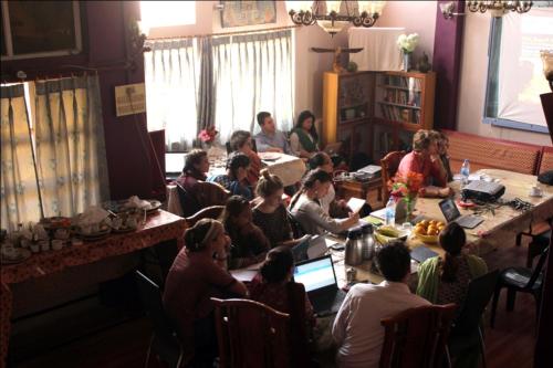 瓦拉纳西Sahi River View Guest house的一群人坐在一个房间里桌子旁