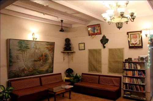 瓦拉纳西Sahi River View Guest house的客厅配有沙发,墙上挂着一幅大画