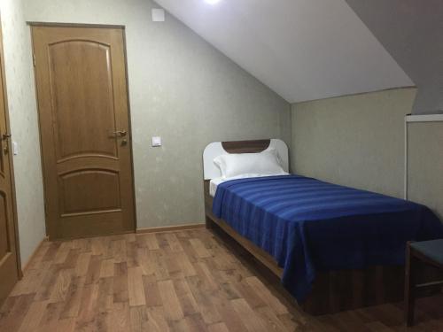 KhorogZarya Hotel的小卧室配有一张带蓝色毯子的床