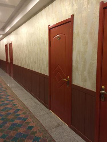 乌兰巴托Atlas Hotel的走廊上一排红色的门