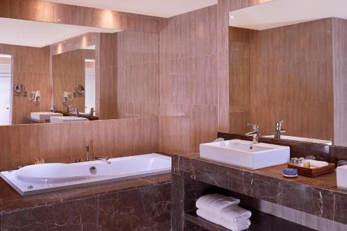 马特鲁港Jaz Crystal, Almaza Bay的浴室设有2个水槽、浴缸和镜子