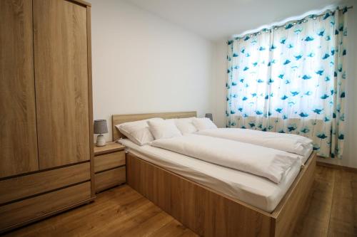 索普隆Napfény Apartman的一间卧室配有一张带蓝色窗帘的大床