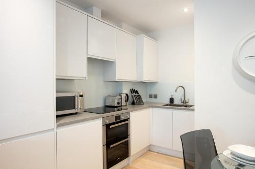 温莎Hampden Apartments - The George的白色的厨房配有白色橱柜和水槽