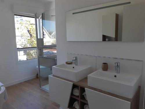加来le vergoyer的白色的浴室设有两个盥洗盆和镜子