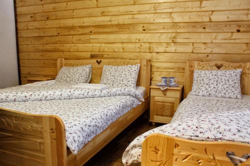 Horná TureckáChata u Petrenkov的一间卧室设有两张床和木墙
