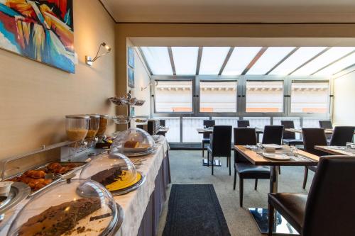 那不勒斯MH设计酒店的餐厅设有桌椅,展示食物