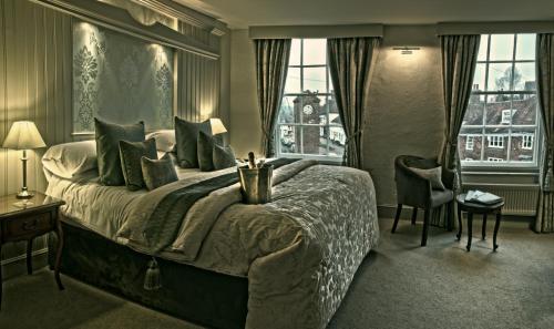 罗伯茨布里奇乔治旅店 的一间卧室设有一张大床和两个窗户。