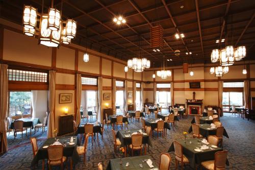 奈良奈良酒店的用餐室配有桌椅和吊灯。
